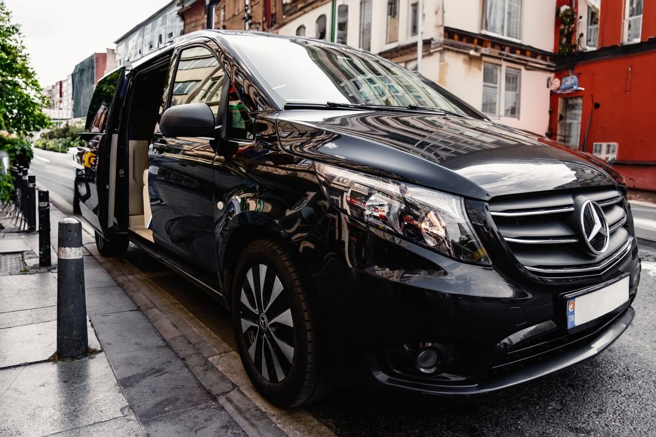 Home A stylish black Mercedes-Benz van parked on a bustling city street, showcasing luxury and modern design.